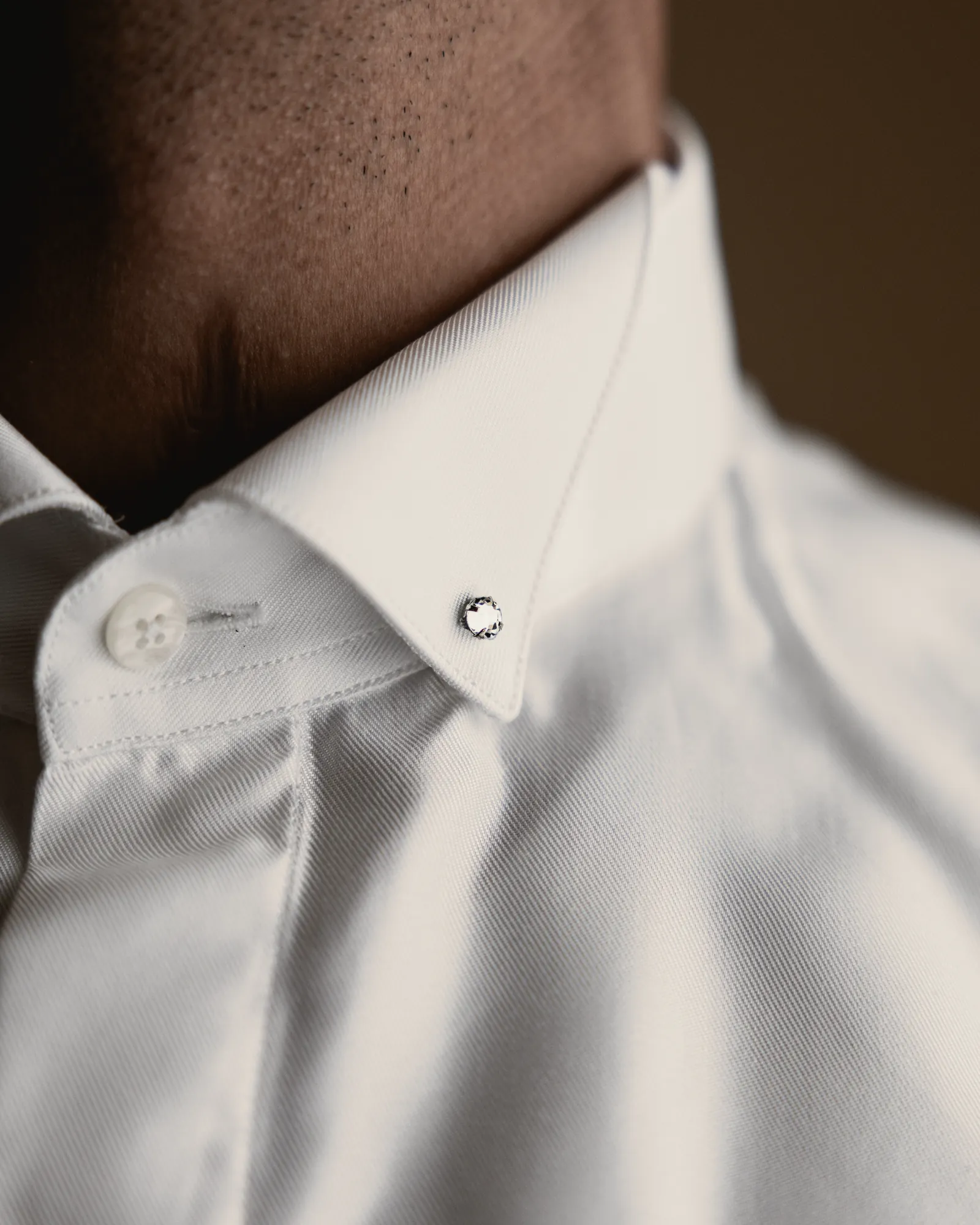 The white collar and its pin, close up.