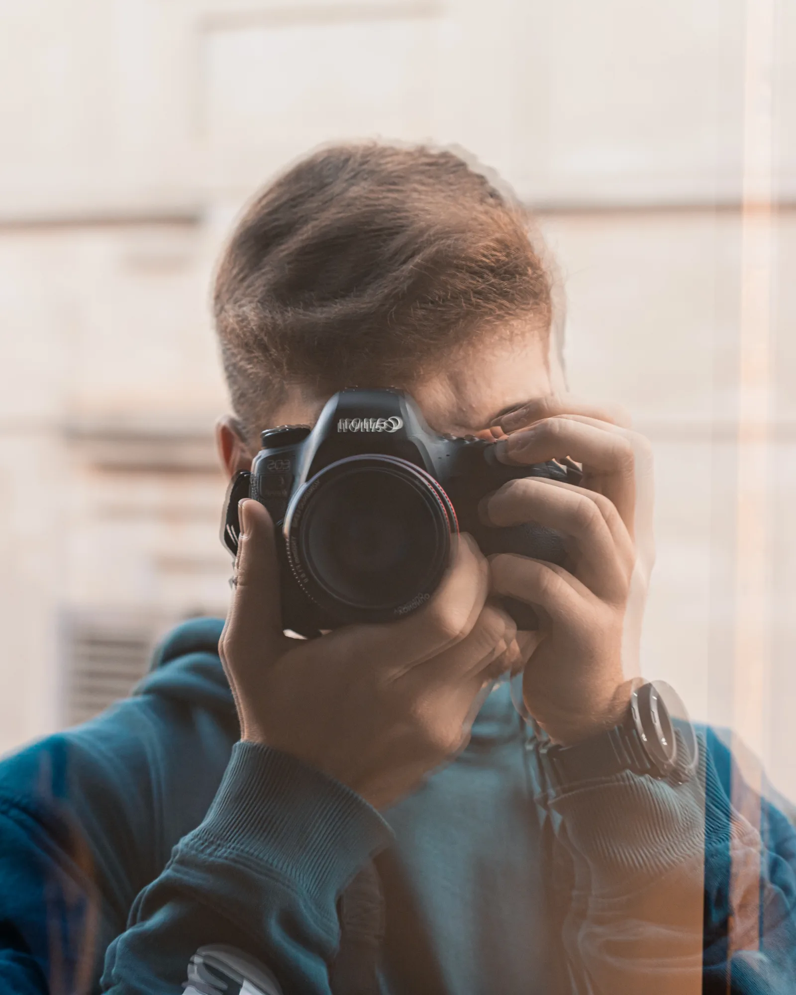 Piergiorgio Di Falco riflesso in una vetrina, la macchina fotografica davanti al viso.